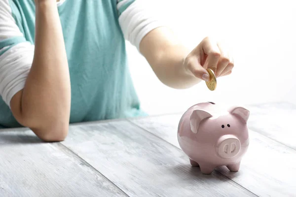 Mão mulher colocando dinheiro moeda em porquinho para economizar dinheiro riqueza e conceito financeiro. — Fotografia de Stock