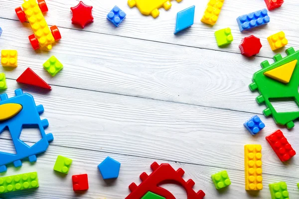 Cadre de jouets colorés pour enfants sur fond en bois. Vue de dessus. Pose plate. Espace de copie pour le texte . — Photo