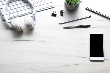 Bilgisayarlı beyaz masa ofisi, akıllı telefon ve bir fincan kahveli diğer iş malzemeleri. Metni kopyalamak için üst görünümü kullan. Desenci çalışma alanı düz masa üzerinde temel elementler yatıyordu