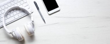 Bilgisayarlı beyaz masa ofisi, akıllı telefon ve bir fincan kahveli diğer iş malzemeleri. Metni kopyalamak için üst görünümü kullan. Desenci çalışma alanı düz masa üzerinde temel elementler yatıyordu