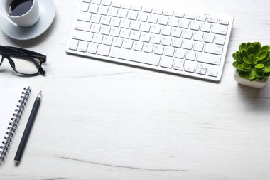 Bilgisayarlı beyaz masa ofisi, akıllı telefon ve bir fincan kahveli diğer iş malzemeleri. Metni kopyalamak için üst görünümü kullan. Desenci çalışma alanı düz masa üzerinde temel elementler yatıyordu