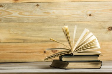 Açık kitap, ahşap masadaki ciltli kitaplar. Okula dönelim. Boşluğu kopyala