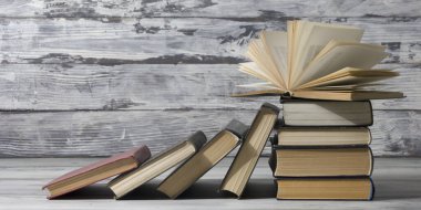 Açık kitap, ahşap masadaki ciltli kitaplar. Okula dönelim. Boşluğu kopyala
