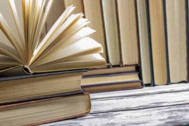 Açık kitap, ahşap masadaki ciltli kitaplar. Okula dönelim. Boşluğu kopyala