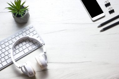Bilgisayarlı beyaz masa ofisi, akıllı telefon ve bir fincan kahveli diğer iş malzemeleri. Metni kopyalamak için üst görünümü kullan. Desenci çalışma alanı düz masa üzerinde temel elementler yatıyordu