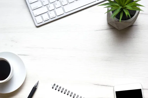 Witte bureau met laptop, smartphone en andere werkbenodigdheden met kopje koffie. Bovenaanzicht met kopieerruimte voor het invoeren van de tekst. Designer werkruimte op bureau tafel essentiële elementen op vlakke lay — Stockfoto