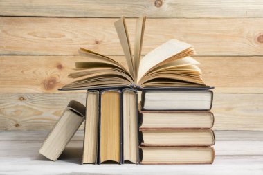 Açık kitap, ahşap masadaki ciltli kitaplar. Okula dönelim. Boşluğu kopyala