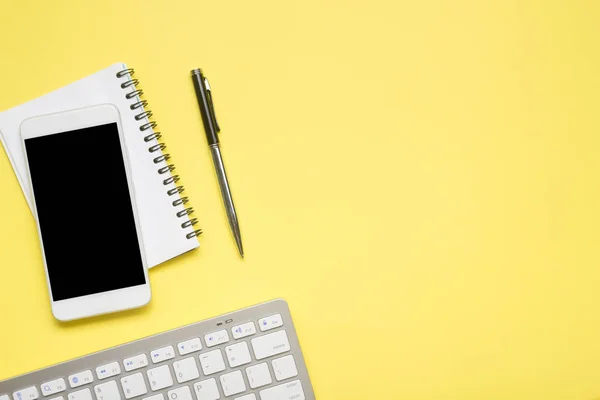 Yellow desk office with laptop, smartphone and other work supplies with cup of coffee. Top view with copy space for input the text. Designer workspace on desk table essential elements on flat lay