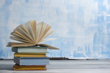 Açık kitap, ahşap masadaki ciltli kitaplar. Okula dönelim. Boşluğu kopyala