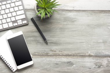 Bilgisayarlı beyaz masa ofisi, akıllı telefon ve bir fincan kahveli diğer iş malzemeleri. Metni kopyalamak için üst görünümü kullan. Desenci çalışma alanı düz masa üzerinde temel elementler yatıyordu