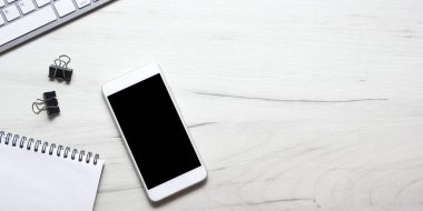 Bilgisayarlı beyaz masa ofisi, akıllı telefon ve bir fincan kahveli diğer iş malzemeleri. Metni kopyalamak için üst görünümü kullan. Desenci çalışma alanı düz masa üzerinde temel elementler yatıyordu