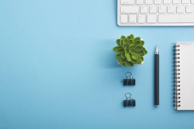 Laptop, akıllı telefon ve bir fincan kahveli diğer iş gereçleri olan sarı masa ofisi. Metni kopyalamak için üst görünümü kullan. Desenci çalışma alanı düz masa üzerinde temel elementler yatıyordu