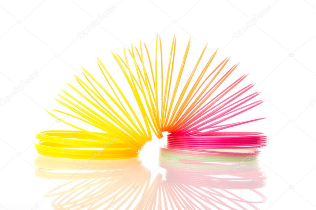 Rainbow colored wire spiral toy on white background