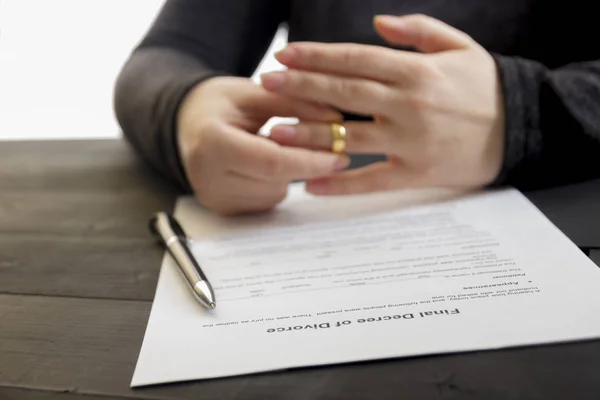 Руки дружини, чоловік підписує декрет про розлучення, розірвання шлюбу, скасовує шлюб, юридично розділяє документи, подає документи про розлучення або договір про шлюб, підготовлений адвокатом. Обручка — стокове фото