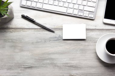 Bilgisayarlı beyaz masa ofisi, akıllı telefon ve bir fincan kahveli diğer iş malzemeleri. Metni kopyalamak için üst görünümü kullan. Desenci çalışma alanı düz masa üzerinde temel elementler yatıyordu