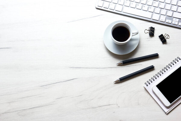 White desk office with laptop, smartphone and other work supplies with cup of coffee. Top view with copy space for input the text. Designer workspace on desk table essential elements on flat lay