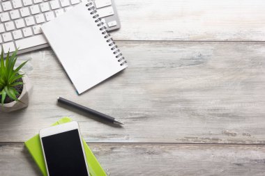 Bilgisayarlı beyaz masa ofisi, akıllı telefon ve bir fincan kahveli diğer iş malzemeleri. Metni kopyalamak için üst görünümü kullan. Desenci çalışma alanı düz masa üzerinde temel elementler yatıyordu