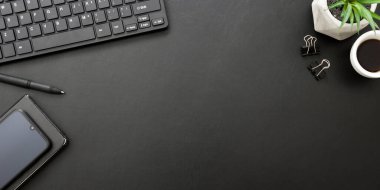 Laptop, akıllı telefon ve bir fincan kahveli diğer iş malzemeleri olan siyah masa ofisi. Metni kopyalamak için üst görünümü kullan. Desenci çalışma alanı düz masa üzerinde temel elementler yatıyordu