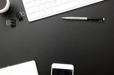 Laptop, akıllı telefon ve bir fincan kahveli diğer iş malzemeleri olan siyah masa ofisi. Metni kopyalamak için üst görünümü kullan. Desenci çalışma alanı düz masa üzerinde temel elementler yatıyordu