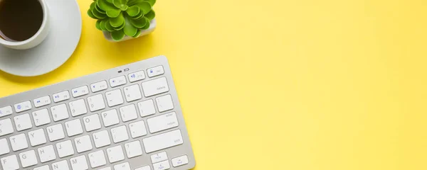 Yellow desk office with laptop, smartphone and other work supplies with cup of coffee. Top view with copy space for input the text. Designer workspace on desk table essential elements on flat lay