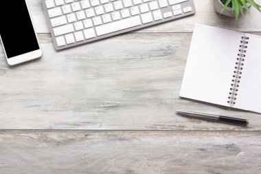 Bilgisayarlı beyaz masa ofisi, akıllı telefon ve bir fincan kahveli diğer iş malzemeleri. Metni kopyalamak için üst görünümü kullan. Desenci çalışma alanı düz masa üzerinde temel elementler yatıyordu