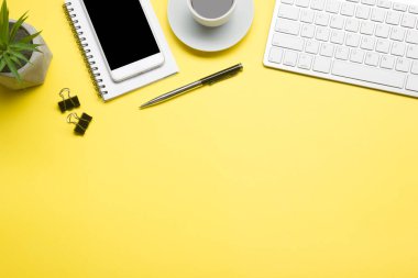 Bilgisayarlı beyaz masa ofisi, akıllı telefon ve bir fincan kahveli diğer iş malzemeleri. Metni kopyalamak için üst görünümü kullan. Desenci çalışma alanı düz masa üzerinde temel elementler yatıyordu