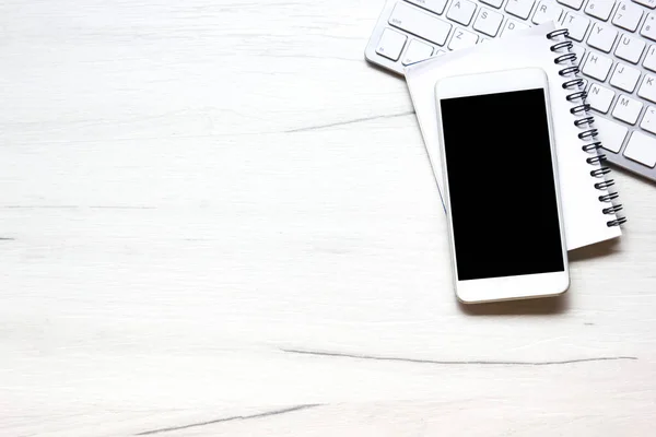 White desk office with laptop, smartphone and other work supplies with cup of coffee. Top view with copy space for input the text. Designer workspace on desk table essential elements on flat lay