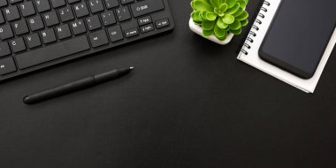 Laptop, akıllı telefon ve bir fincan kahveli diğer iş malzemeleri olan siyah masa ofisi. Metni kopyalamak için üst görünümü kullan. Desenci çalışma alanı düz masa üzerinde temel elementler yatıyordu