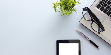 Dizüstü bilgisayarı, akıllı telefonu ve bir fincan kahveli diğer iş malzemeleri olan mavi masa ofisi. Metni kopyalamak için üst görünümü kullan. Desenci çalışma alanı düz masa üzerinde temel elementler yatıyordu