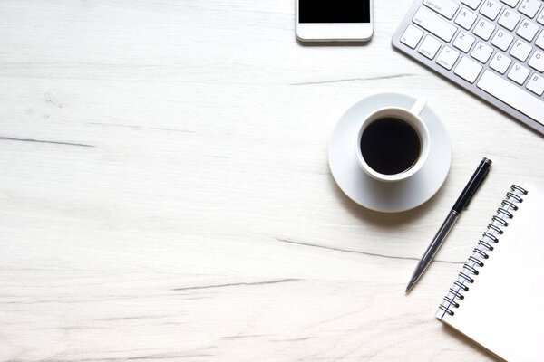 White desk office with laptop, smartphone and other work supplies with cup of coffee. Top view with copy space for input the text. Designer workspace on desk table essential elements on flat lay