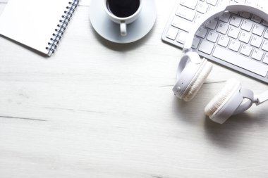 Bilgisayarlı beyaz masa ofisi, akıllı telefon ve bir fincan kahveli diğer iş malzemeleri. Metni kopyalamak için üst görünümü kullan. Desenci çalışma alanı düz masa üzerinde temel elementler yatıyordu
