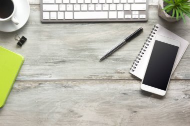 Bilgisayarlı beyaz masa ofisi, akıllı telefon ve bir fincan kahveli diğer iş malzemeleri. Metni kopyalamak için üst görünümü kullan. Desenci çalışma alanı düz masa üzerinde temel elementler yatıyordu