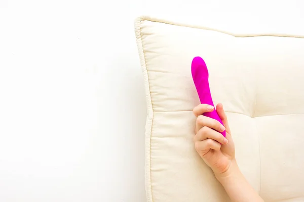 Mulher na cama segurando um vibrador. Brinquedo sexual para adulto — Fotografia de Stock