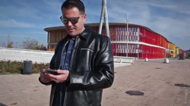 Yaşam tarzı ve teknoloji. Adam onun smartphone sokağa bakan. Güneş ve günbatımı