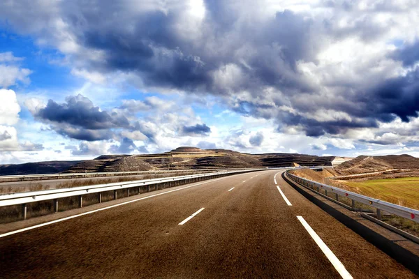 Estrada vazia, paisagem montanhosa e céu nublado. Conceito de viagem de carro e estrada — Fotografia de Stock
