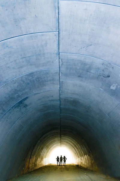 Tunnel en béton et silhouettes femme — Photo