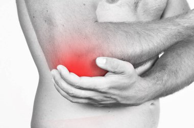 Bir ağrı nedeniyle dirseğini tutan adam.