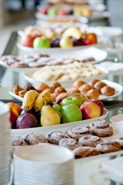 Tafel bedekt met cakes en fruit — Stockfoto