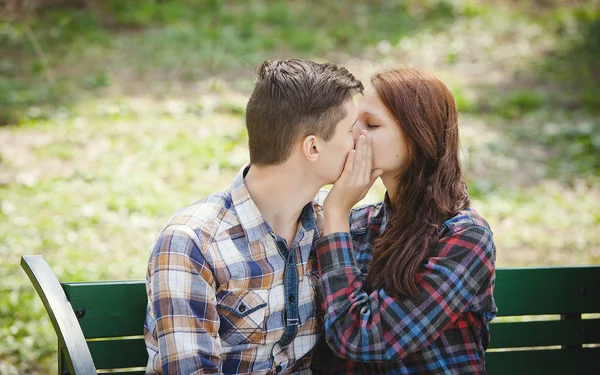 Paar küsst sich auf der Bank — Stockfoto