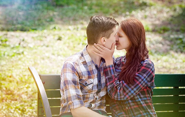 Couple kissing on the bench — Stock Photo, Image