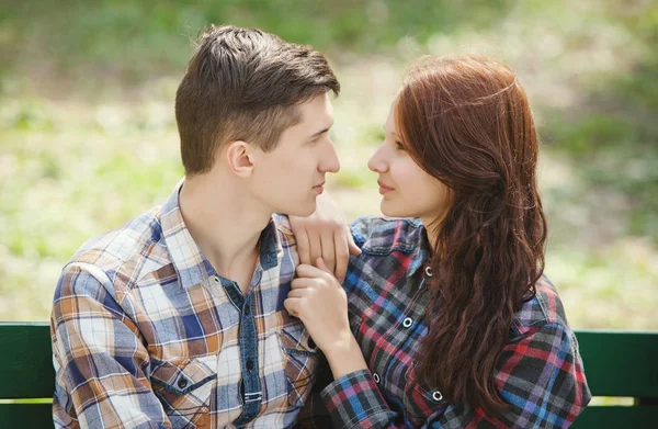 Flirten jonge paar op een bankje — Stockfoto