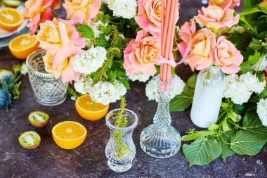 Güller, mumlar ve meyvelerle dolu bir masada düğün dekoru