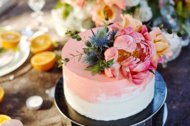 Düğün dekoru pasta, mum ve meyvelerle dolu bir masada.