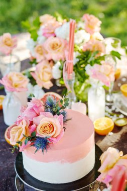 Düğün dekoru pasta, mum ve meyvelerle dolu bir masada.