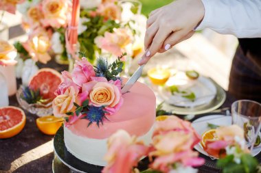 Düğün dekoru pasta, mum ve meyvelerle dolu bir masada.