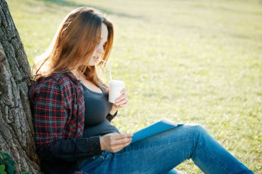 Ağacın yanındaki kız öğrenci dersin ve hayallerin başlamasını bekliyor.