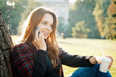 Ağacın yanındaki kız öğrenci dersin ve hayallerin başlamasını bekliyor.