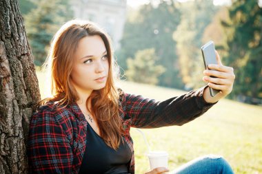 Ağacın yanındaki kız öğrenci dersin ve hayallerin başlamasını bekliyor.