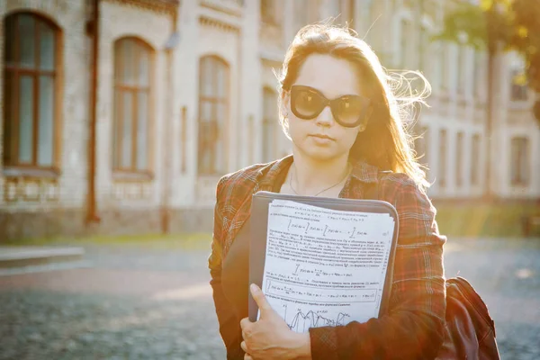 student near university building after writing an exam