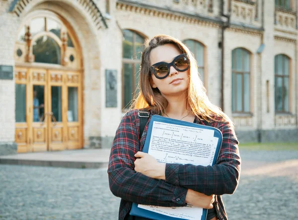 student near university building after writing an exam